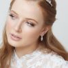 Princess wedding earrings in silver being worn on ears